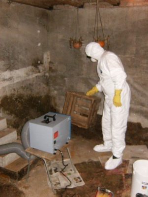 Entsorgungsarbeiten im feuchten Keller mit Schutzanzug